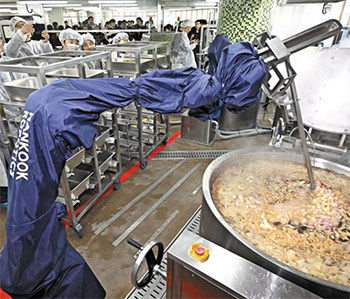 ▲11月22日、ソウル市城北区にある崇谷中学校の調理室で、給食ロボットが釜に入ったスープをかき混ぜている。／チャン・リョンソン記者