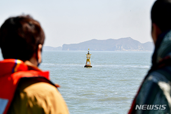 ▲全羅南道珍島郡東巨次島沖合の旅客船セウォル号沈没現場で当時救助活動を行った民間潜水士たち。沖合には沈没現場を示すブイが設置されている。2023年4月9日撮影。／NEWSIS＝イ・ヨンジュ記者